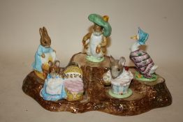 A COLLECTION OF BESWICK BEATRIX POTTER FIGURES ON A BESWICK TREE STUMP DISPLAY STAND