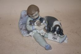 A LLADRO FIGURE OF A SEATED BOY WITH A DOG AND PUPPIES