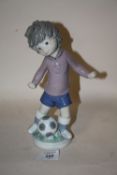 A LLADRO FIGURE OF A BOY WITH A FOOTBALL SPORT - BILLY PRODUCTIONS 1,978 HEIGHT - 23CM