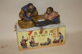A BOXED AOYIMEITAO ORIENTAL CERAMIC FIGURE OF A MAN AND CHILD PLAYING CHECKERS