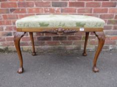A REPRODUCTION CHIPPENDALE STYLE UPHOLSTERED STOOL ON BALL AND CLAW FEET H-55 W-90 CM