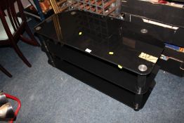 A MODERN BLACK GLASS TV STAND