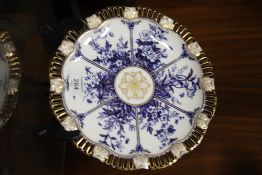 AN ANTIQUE COALPORT BLUE, WHITE AND GILT RIBBON PLATE ON STAND