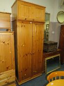 A HONEY PINE DOUBLE WARDROBE WITH AN ADDED TOP BOX