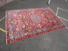 AN EASTERN WOOLLEN RUG MAINLY RED / PINK GROUND 235 X 156 CM