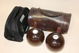 A PAIR OF LAWN BOWLS TOGETHER WITH A LEATHER CARRY BAG