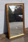 A LARGE CONTEMPORARY GILT FRAMED WALL MIRROR 70 X 128 CM