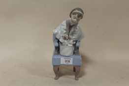 A LLADRO FIGURE OF A YOUNG GIRL STANDING ON AN ARM CHAIR WITH KITTENS MARKED 1998 EVENT FIGURINE
