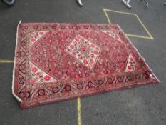 AN EASTERN WOOLLEN RUG MAINLY RED / CREAM GROUND 213 X 155 CM