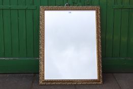 A LARGE GILT FRAMED BEVEL EDGE WALL MIRROR, OVERALL SIZE INCLUDING FRAME 89 X 105 CM