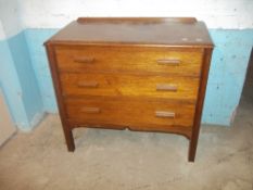 AN OAK CHEST OF DRAWERS