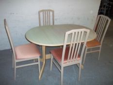AN EXTENDING BEAUTILITY DINING TABLE AND FOUR CHAIRS