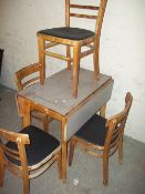 A VINTAGE DROP LEAF FORMICA KITCHEN TABLE AND FOUR CHAIRS