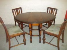 AN EARLY 1900S OAK DROP LEAF DINING SET WITH FOUR CHAIRS