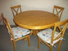 A ROUND DINING TABLE WITH FOUR CHAIRS