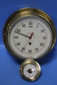 A BRASS PORT HOLE STYLE CLOCK WITH KEY TOGETHER WITH A SMALL BRASS BAROMETER¦Condition Report:The