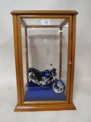 A GLASS DISPLAY CASE CONTAINING A MODEL HONDA MOTORBIKE
