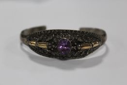 A VINTAGE STERLING SILVER AND AMETHYST BANGLE WITH FLORAL DETAIL APPROX WEIGHT - 21.1G