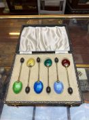 A CASED SET OF SIX ART DECO SILVER GILT AND ENAMEL COFFEE SPOONS, with turned wood bean terminals,