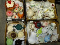 FOUR TRAYS OF TEAPOTS, CREAM JUGS, SUGAR BOWLS, AND NOVELTY CAKE CERAMICS
