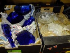 A TRAY OF DECORATIVE BLUE GLASS VASES AND BOWLS TOGETHER WITH A TRAY OF CLEAR GLASS TO INCLUDE A