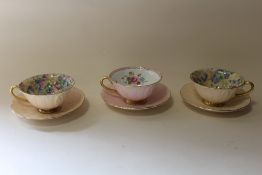 THREE VINTAGE SHELLEY CUPS AND SAUCERS WITH FLORAL INTERIORS, PINK EXAMPLE WITH DAMAGE TO BASE