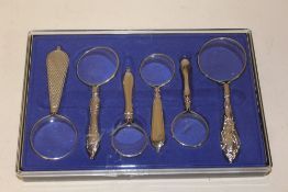 A CASED SET OF SIX MAGNIFYING GLASSES