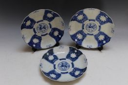 THREE ORIENTAL STYLE BLUE AND WHITE PLATES, having scalloped edging and character mark to base,