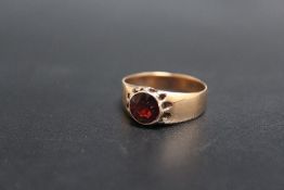 A GARNET STYLE DRESS RING, set in yellow metal with marks indistinct, approx weight 3.6g, ring