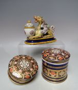 A FAIENCE POTTERY INKWELL IN THE FORM OF A RECUMBENT GRIFFIN, W 15 cm, together with two Imari