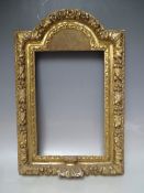A 17TH CENTURY CONTINENTAL DECORATIVE CARVED WOODEN FRAME WITH ARCHED TOP, frame W 7 cm, rebate 40 x