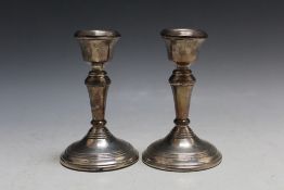 A PAIR OF MODERN SHORT HALLMARKED SILVER CANDLESTICKS - BIRMINGHAM 1979, having filled bases, H 11