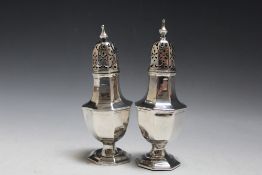 A PAIR OF HALLMARKED SILVER CASTORS, hallmarks indistinct, various bumps and faults, one with filled