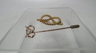 AN UNMARKED YELLOW METAL 'STAFFORDSHIRE KNOT' BROOCH, W 3.5 cm, together with an unmarked yellow