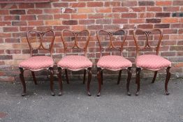 A SET OF FOUR VICTORIAN ROSEWOOD DINING CHAIRS, the shaped backs with scrolling supports, raised