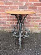 A MID 20TH CENTURY CAST IRON PEDESTAL GARDEN TABLE WITH LATER OAK TOP the circular top raised on
