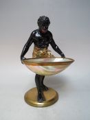 A VINTAGE SPELTER BLACKAMOOR CARD HOLDER, the figure with alter painted detail holding a large