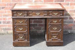 A LATE 19TH CENTURY OAK LEATHER TOPPED TWIN PEDESTAL DESK, the top inset with a red leather