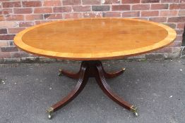 A 19TH CENTURY MAHOGANY AND SATINWOOD BANDED OVAL TILT-TOP TABLE, raised on a turned column and four