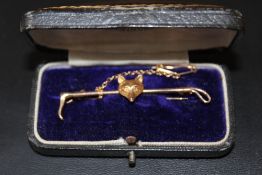A 9 CARAT GOLD FOX HEAD AND RIDING CROP BAR BROOCH, with safety chain, approx weight 2.7g, W 5.5 cm