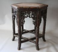 AN ORIENTAL HARDWOOD JARDINIERE STAND, the hexagonal top with an inset marble panel, the stand