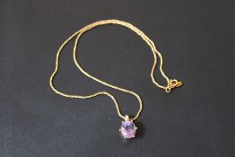 A HALLMARKED 9 CARAT GOLD AMETHYST PENDANT AND CHAIN, the oval amethyst is in a six claw setting,