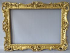 A 19TH CENTURY CARVED WOODEN DECORATIVE GILT SWEPT FRAME, frame W 7 cm, rebate 58 x 42 cm