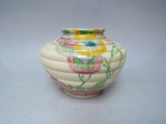 A CLARICE CLIFF WILKINSON POTTERY RHODANTHE PATTERN VASE OF SQUAT RIBBED FORM, decorated with a