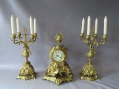 A TWENTIETH CENTURY GILT BRASS THREE PIECE CLOCK GARNITURE, in the Rococo style, raised on a fixed
