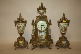 A MODERN BRASS AND CERAMIC CLOCK GARNITURE WITH FIGURATIVE DETAIL