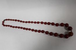 A VINTAGE CHERRY AMBER STYLE GRADUATED BEAD NECKLACE CENTRAL BEAD SIZE 1.7CM