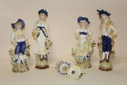 A COLLECTION OF FOUR GLAZED BISQUE STYLE FIGURES PLUS FOUR FLOWERS