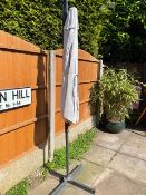 A LARGE GARDEN PARASOL WITH STAND - USED CONDITION