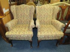 A PAIR OF TRADITIONALLY UPHOLSTERED WING ARMCHAIRS